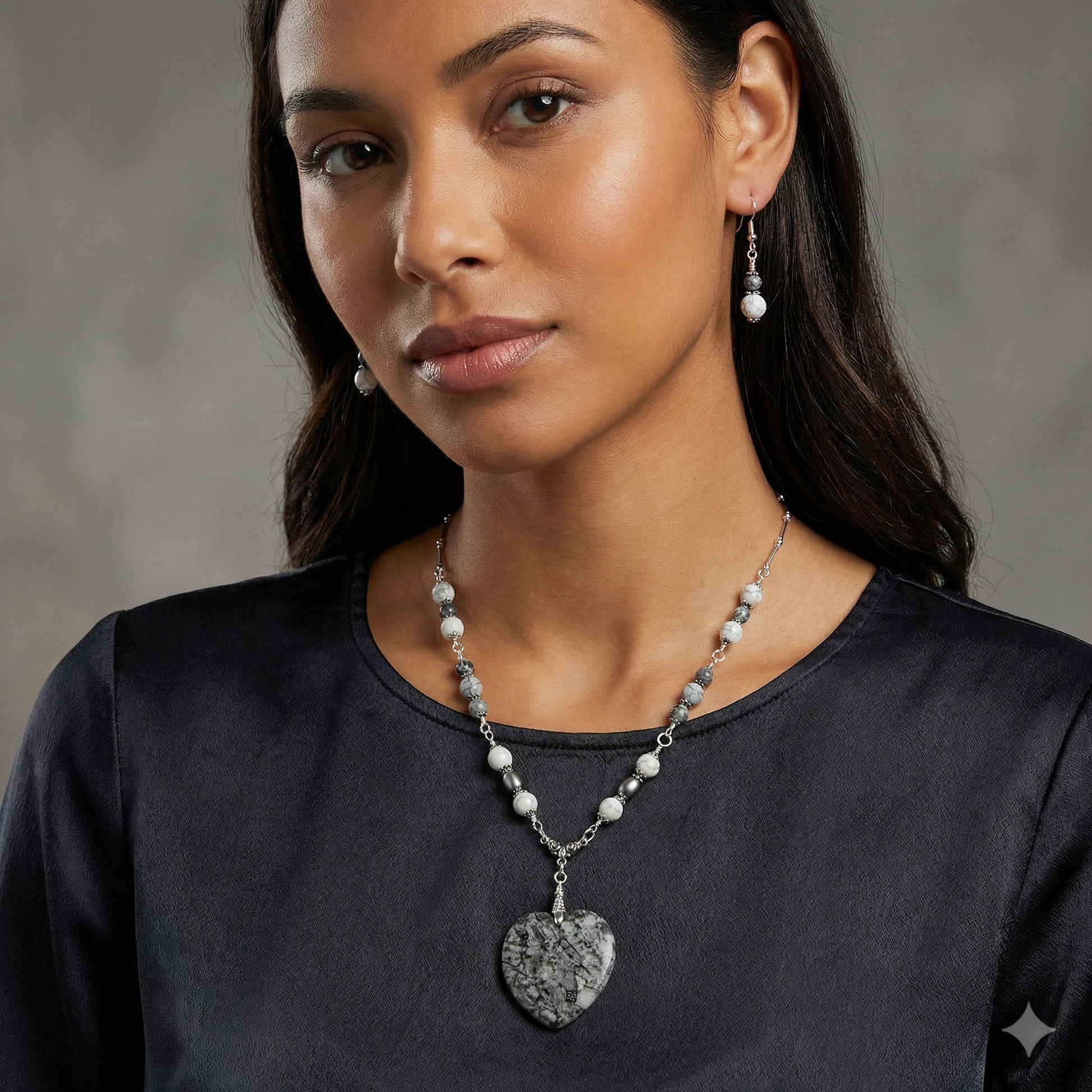 Woman wearing a necklace and earrings against a neutral background