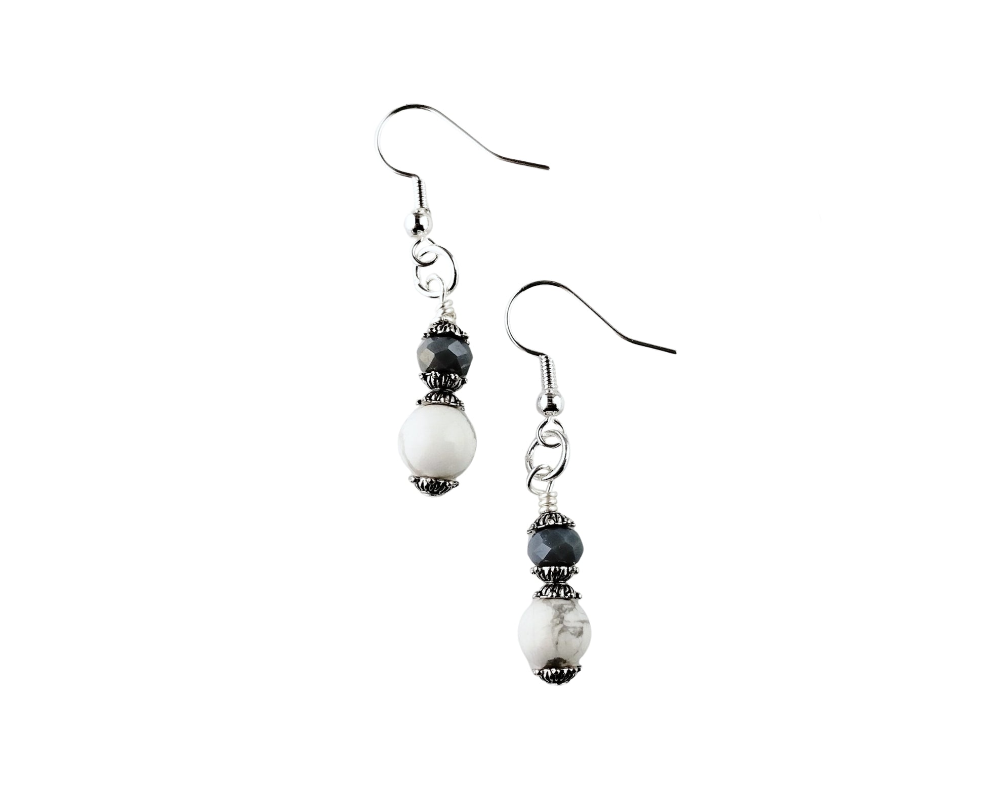 Pair of earrings with white and black beads on a white background