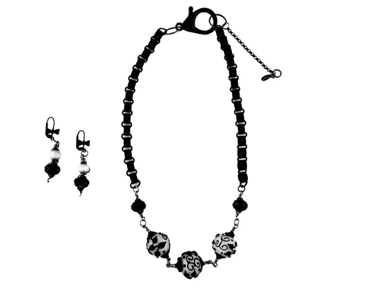 Black beaded necklace and earrings on a white background