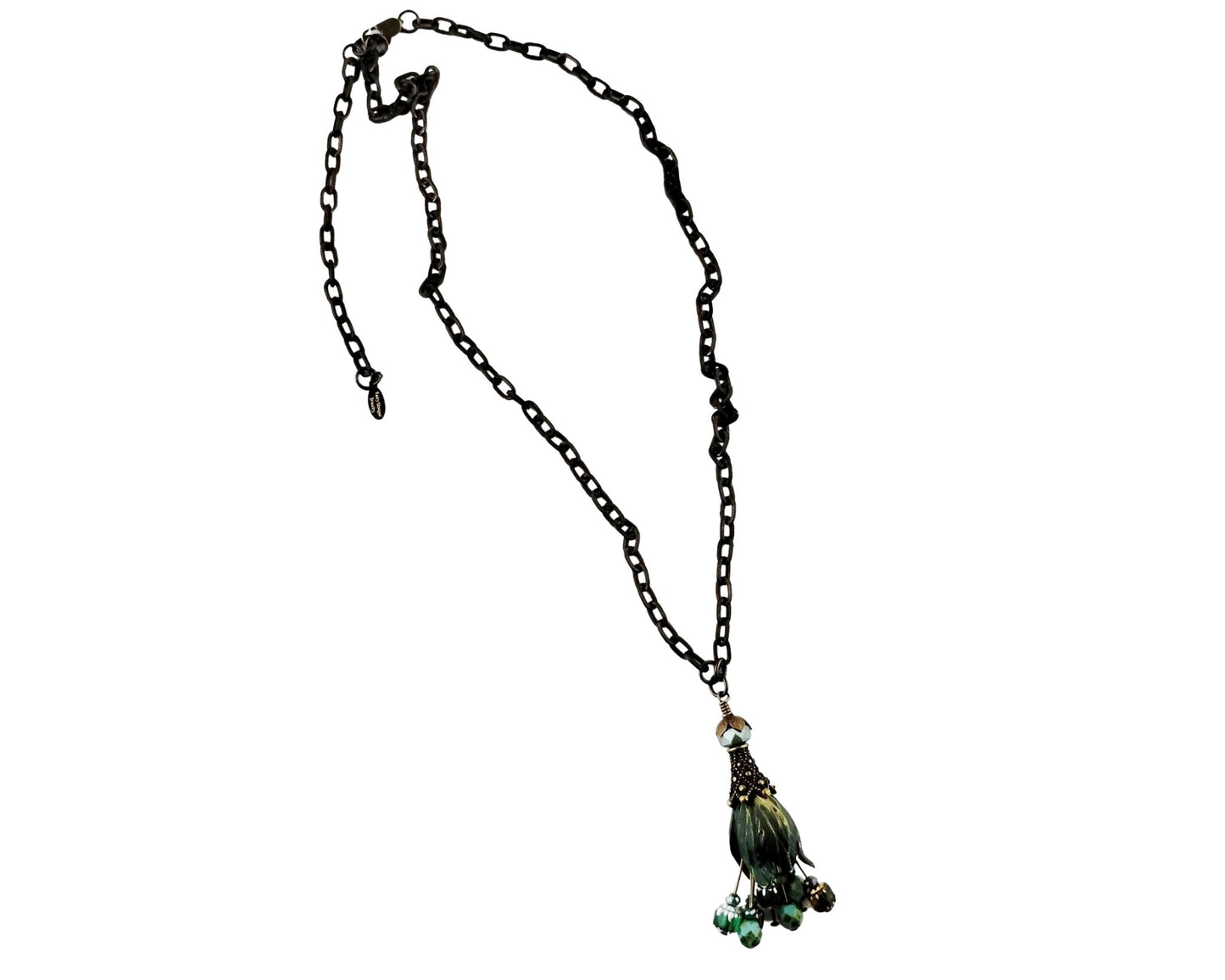 A long brass chain necklace with a decorative tassel pendant featuring green beads, shown against a plain white background.