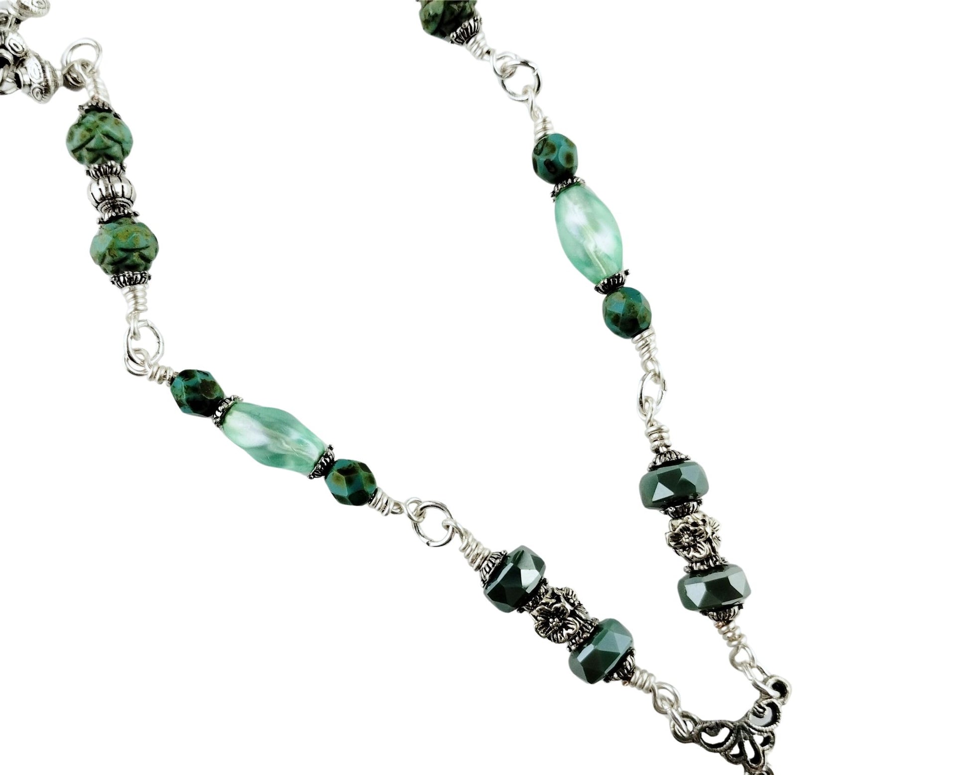 Close-up of green gemstone necklace with silver saucer bead chain