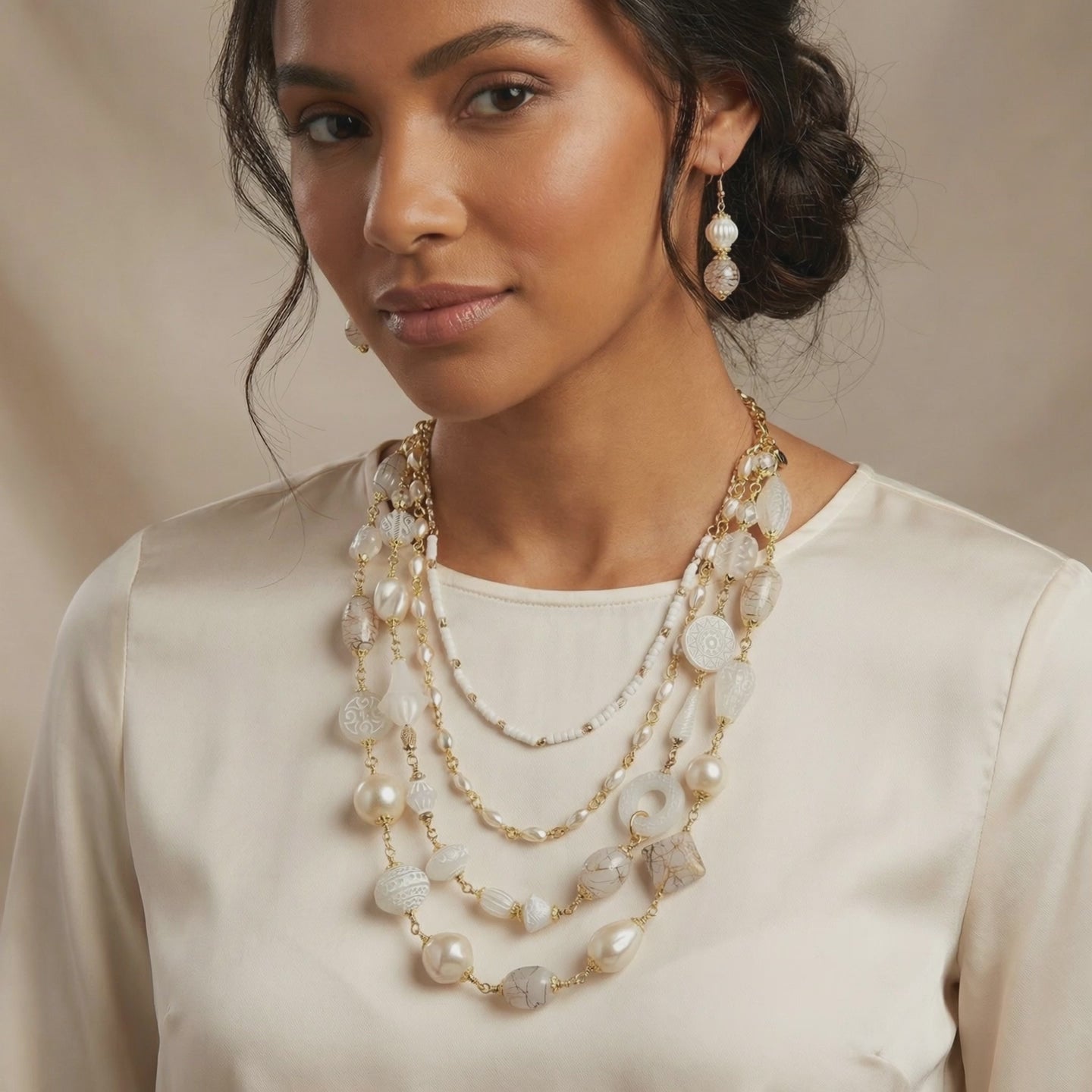 Video of woman wearing a white multilayer necklace. 