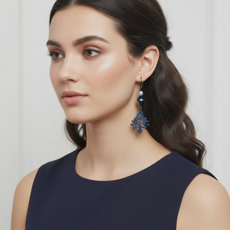 Video of a model wearing blue filigree earrings.